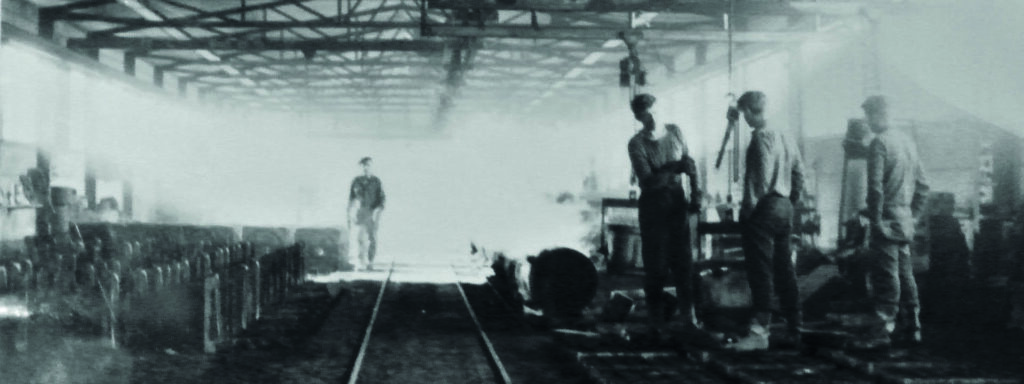 Historisk bilde av arbeidere som jobber i fabrikk. Foto.