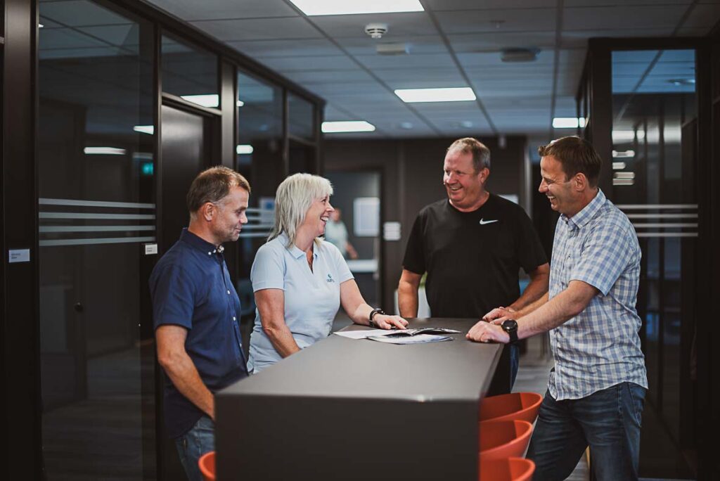 Fire ansatte i Ulefos diskuterer rundt bord. Foto.