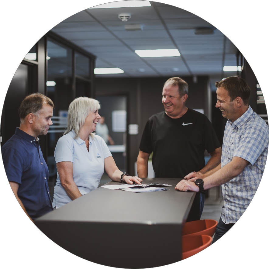 Fire ansatte i Ulefos snakker sammen rundt bord. Foto.