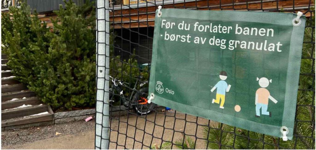 Skilt med informasjon om at man må børste av seg granulat før man forlater kunstgressbane. Foto.