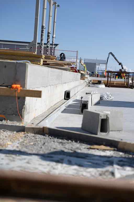 Ulefos Filcoten One dreneringsrenner legges langs betongkant. Foto.